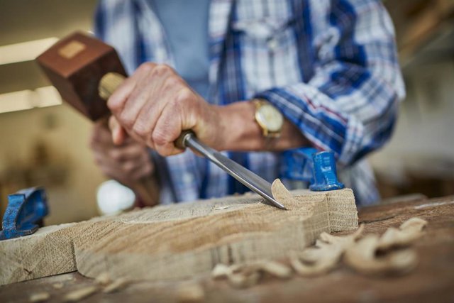 Archivo - Una persona trabaja con madera.