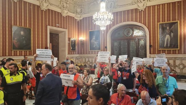 Momento de la protesta de los vecinos en el Pleno del Ayuntamiento de Sevilla antes de ser desalojados por la Policía Local.