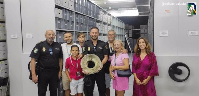 Agentes de la Policía Adscrita y la familia del menor que encontró la pieza durante la vistia al Museo Arqueológico de Almería.