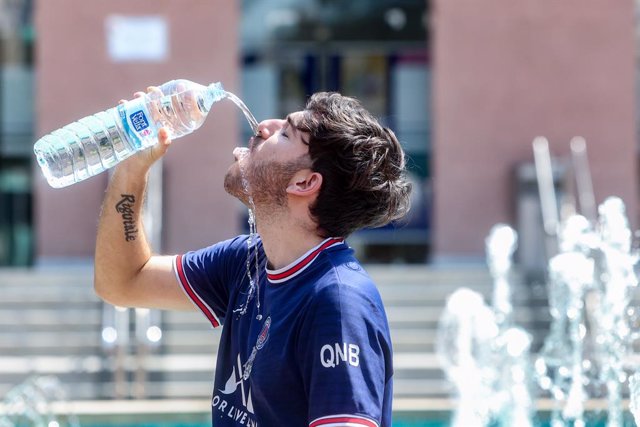 Archivo - Un joven bebe agua para combatir la segunda ola de calor del verano, a 12 de julio de 2022, en Madrid (España).