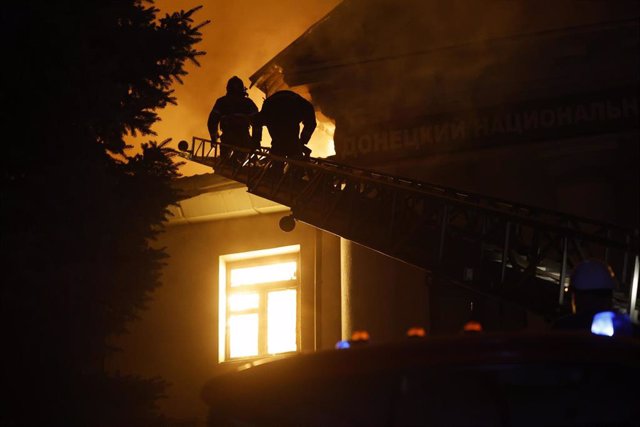 Servicios de Emergencia de Ucrania intentan apagar las llamas tras un ataque contra un edificio residencial en Donetsk, Ucrania