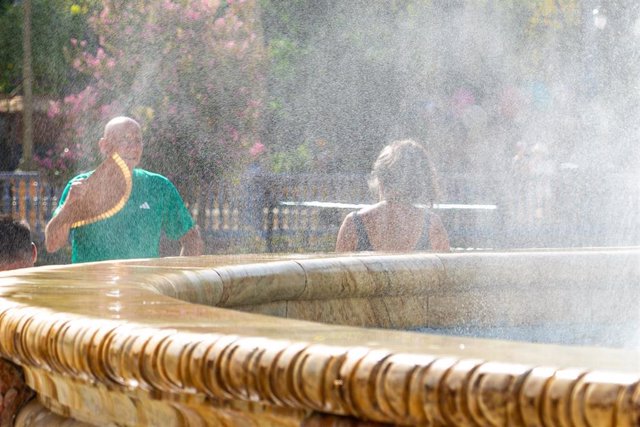 Turistas se refrescan en la fuente de la Plaza de España, en plena ola de calor a 07 de agosto del 2023 en Sevilla (Andalucía, España)