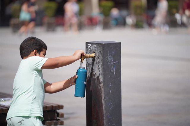Un niño llena una botella de agua en una fuente, a 9 de agosto de 2023, en Vitoria Gasteiz, Álava, País Vasco (España). Euskadi permanece hoy en alerta naranja por calor extremo que tornará a alerta roja entre las 15 y las 18 horas. Justo en ese tramo hor