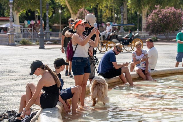 Turistas se refrescan en la fuente de la Plaza de España en plena ola de calor. Imagen de archivo.