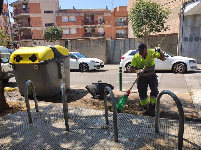 Un trabajador municipal limpiando el lugar donde se ha quemado un contenedor en la ciudad de Lleida