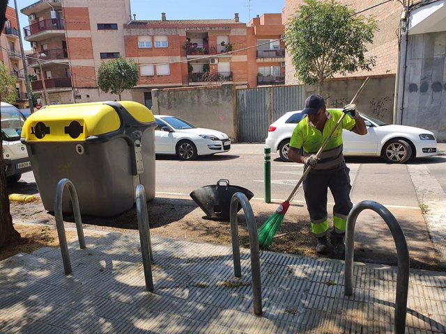 Un treballador municipal netejant el lloc on s'ha cremat un contenidor a la ciutat de Lleida