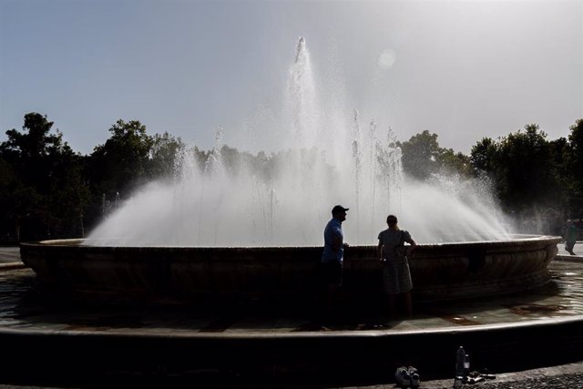 Turistas se refrescan en la fuente de la Plaza de España.