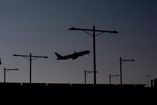 Archivo - Un avión sobrevuela el Aeropuerto de Barcelona-El Prat