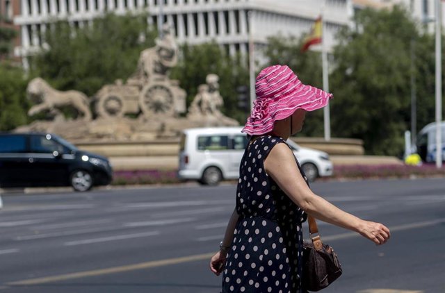 Una mujer pasea por una calle de Madrid con sombrero
