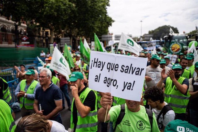 Archivo - Un hombre con un cartel en el que se lee: '¡Hay que salvar al agro ya!' durante una tractorada frente al Ministerio de Agricultura.