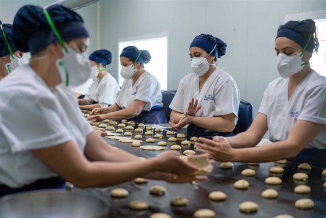 Operarias de la firma sevillana Inés Rosales, en una fase del proceso de fabricación de tortas artesanas.