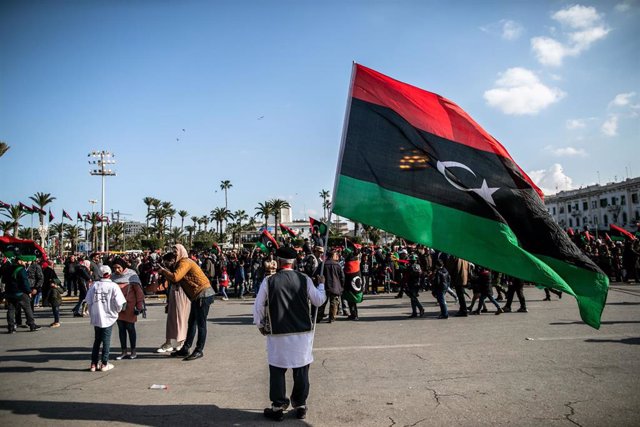 Archivo - Imagen de archivo de un hombre con la bandera libia en una manifestación en Trípoli