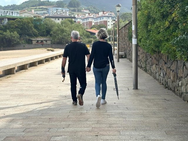 Una pareja transita por un paseo marítimo en Bizkaia pertrechados de paraguas