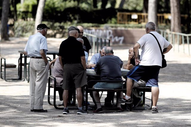 Archivo - Varios pensionistas juegan al dominó en un parque de Madrid