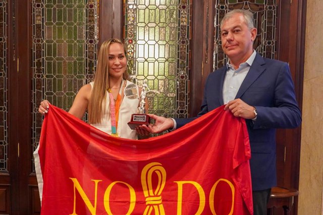 Irene Guerrero y el alcalde de Sevilla portan la bandera de la ciudad.