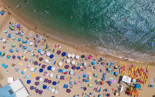 Numerosas personas disfrutan de un día de playa en la Costa Brava, a 30 de julio de 2023, en Tossa de Mar, Girona, Cataluña (España).  