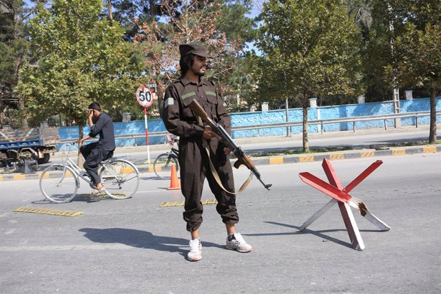 Archivo - Un membre de les forces de seguretat afganeses a prop de l'escenari d'una explosió a Kabul