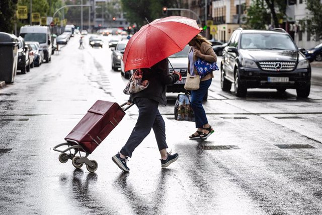 Dos personas caminan bajo la lluvia, a 2 de septiembre de 2023, en Madrid (España).