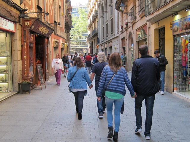 Archivo - Gente paseando por una calle comercial de Barcelona