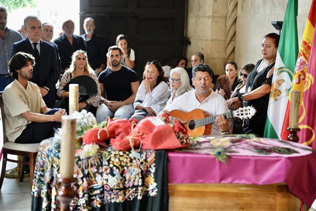 Un hombre, guitarra en mano, canta a la artista María Jiménez en la Capilla Ardiente instalada en el Ayuntamiento de Sevilla