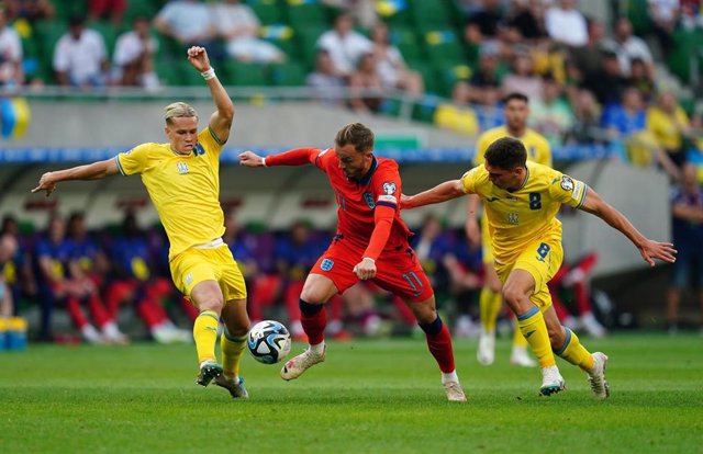 09 September 2023, Poland, Wroclaw: England's James Maddison (C) battles for the ball with Ukraine's Mykhailo Mudryk (L) and Georgiy Sudakov during the UEFA Euro 2024 Qualifying Group C soccer match between Ukraine and England at the Tarczynski Arena.