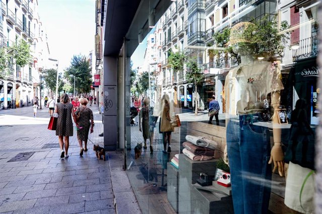 Archivo - Varias personas pasan por delante de un escaparate de una tienda de ropa, a 2 de septiembre de 2022, en Madrid (España). 