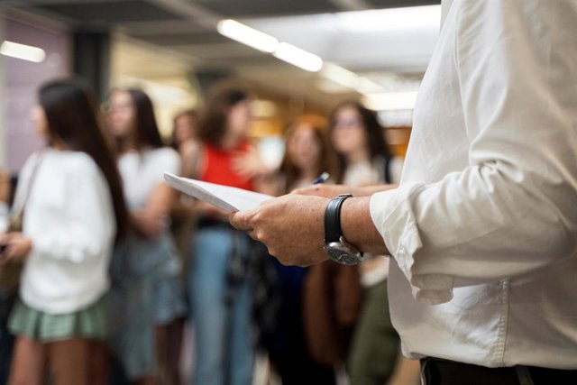 Archivo - Un profesor sujeta una pila de exámenes