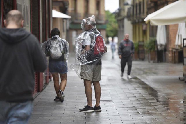 Varias personas caminan bajo la lluvia, a 2 de septiembre de 2023, en Huesca, Aragón (España).   