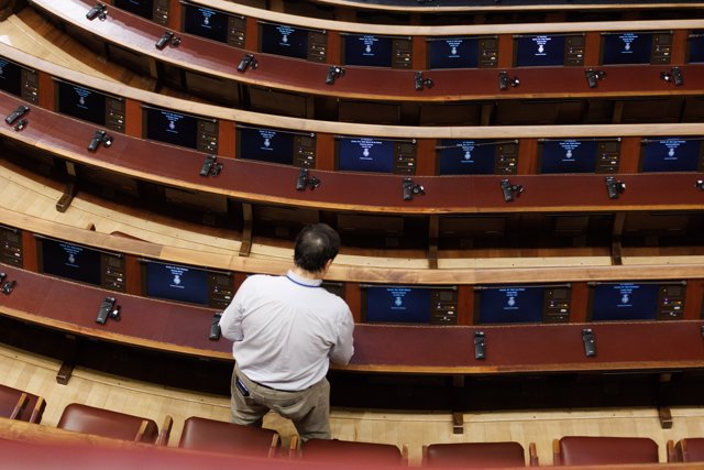 Un hombre prepara los asientos del hemiciclo antes de iniciar una sesión plenaria en la se aprueba el uso de las lenguas cooficiales en el Congreso de los Diputados, a 19 de septiembre de 2023, en Madrid (España). 