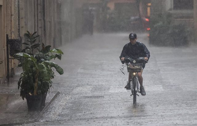 Una persona en bicicleta bajo la lluvia, a 15 de septiembre de 2023, en València