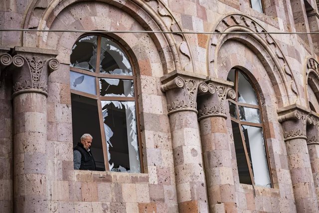 Archivo - Un hombre mira una ventana rota en una iglesia de la localidad de Martuni, en Nagorno Karabaj, durante la guerra entre Armenia y Azerbaiyán en 2020