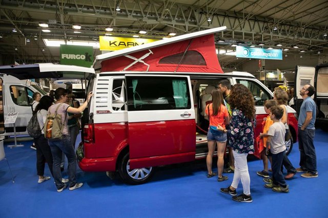 Visitantes observan un vehículo