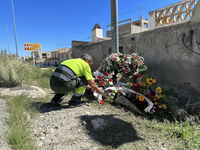Un compañero deposita flores y velas en el lugar del atropello mortal en El Campello