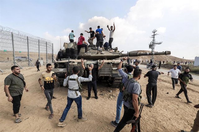 Palestinos sobre un carro de combate israelí en la frontera de la Franja de Gaza
