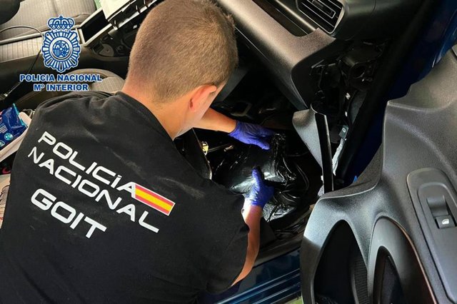 Un agente de Policía Nacional intervieniendo la cocaína incautada en un vehículo. 