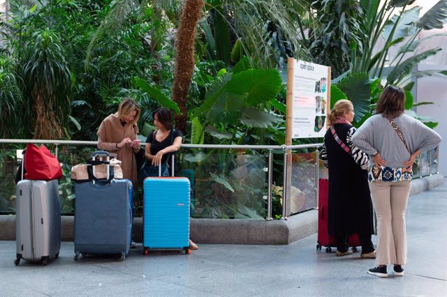 Varias personas esperan con maletas en la estación de Puerta de Atocha-Almudena Grandes.