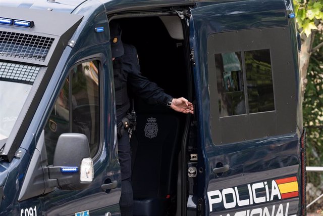Archivo - Un agente de la UIP de Policía Nacional cierra la puerta de un furgón policial.
