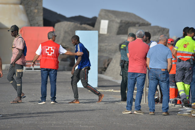 El presidente de Canarias, Fernando Clavijo (2d), observa la llegada de una patera durante su visita al muelle de La Restinga