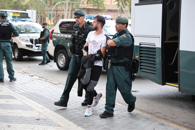 Dos agentes de la Guardia Civil escoltan a un detenido, a 19 de octubre de 2023, en Mallorca, Islas Baleares (España). 