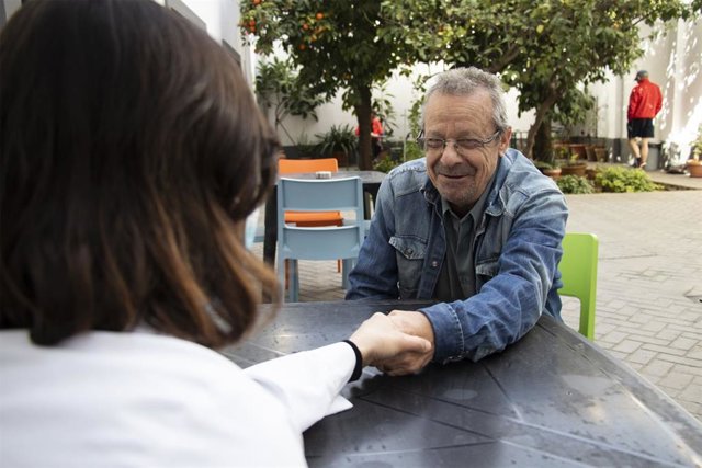 Un voluntario de Cáritas atiende a una persona sin hogar.