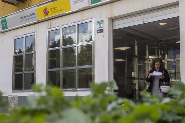 Archivo - Una mujer sale de una oficina de empleo en Sevilla, en una foto de archivo.