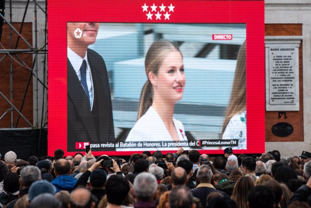 Varias personas siguen en pantallas, preparadas para la ocasión, el Juramento de la Constitución de la Princesa Leonor, en la Puerta del Sol, a 31 de octubre de 2023, en Madrid (España). 