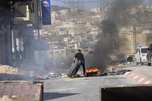 Un palestino quemando neumáticos durante una protesta contra el Ejército de Israel en Cisjordania