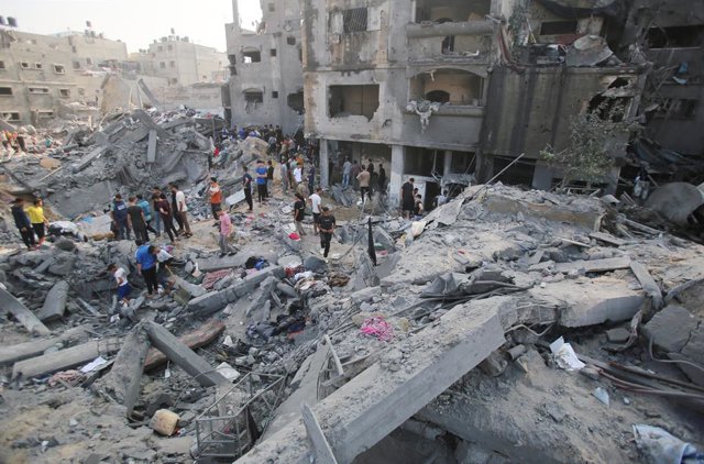 Un grup de persones rastreja la zona d'un atac al campament de refugiats de Jabalia, a la Franja de Gaza