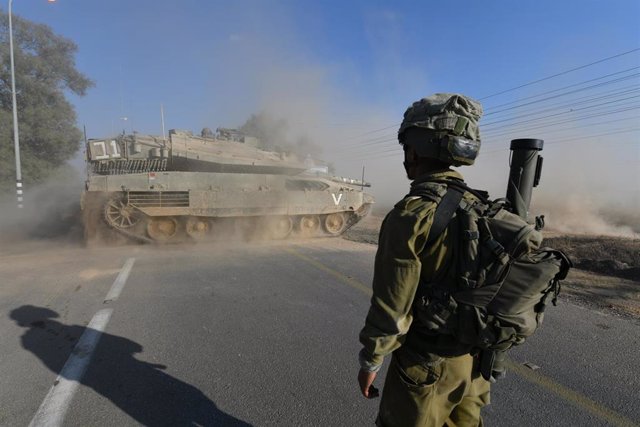 Un soldado israelí junto a un carro de combate en la región de Gaza