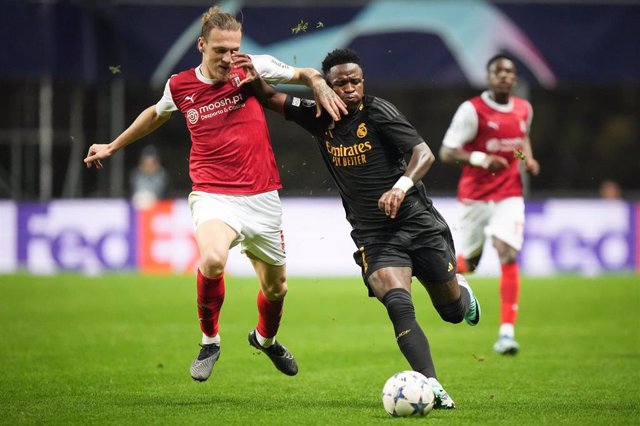 24 October 2023, Portugal, Braga: Braga's Serdar Saatci (L) and Real Madrid's Vinicius Junior battle for the ball during the UEFA Champions League group C soccer match between SC Braga and Real Madrid FC at the Braga Municipal Stadium. Photo: Gonãalo Del