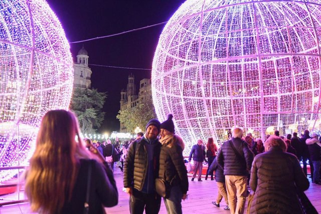 Archivo - Dos personas se hacen una foto durante el encendido de la iluminación navideña de la plaza del Ayuntamiento, a 29 de noviembre de 2021