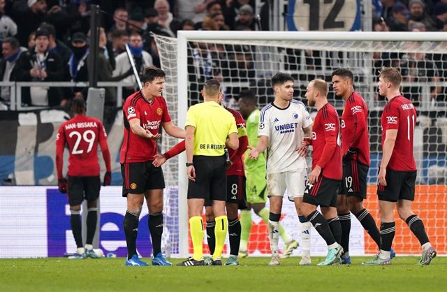 Harry Maguire (L) reacts after being penalised for handball, resulting in a penalty during a UEFA Champions League match.