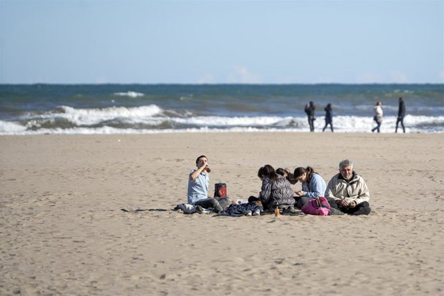 Archivo - Un grupo de personas en la playa de la Malvarrosa