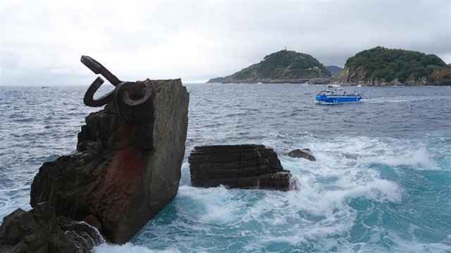 Una embarcación pasa cerca del Peine del Viento, en San Sebastián